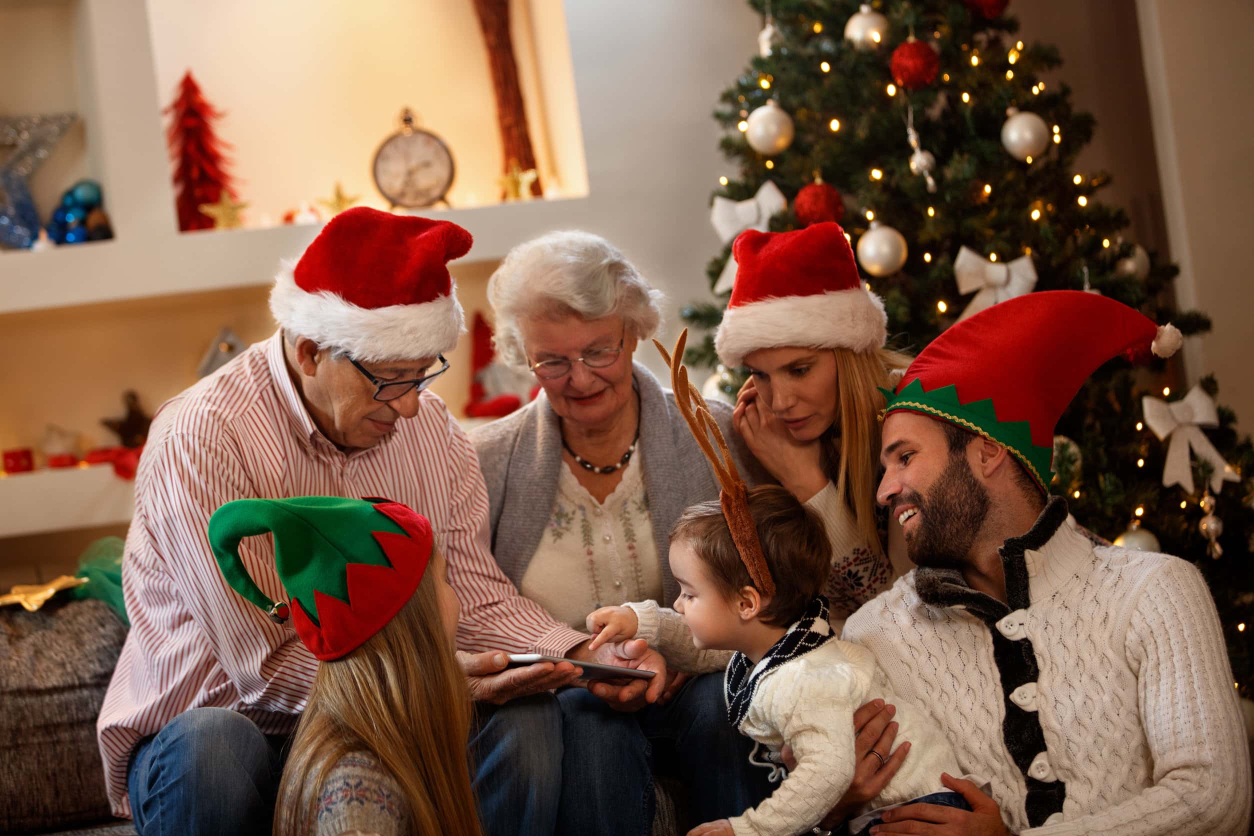a family in Christmas garb looking at a phone together