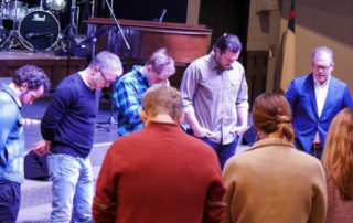 a group bowing their head in prayer