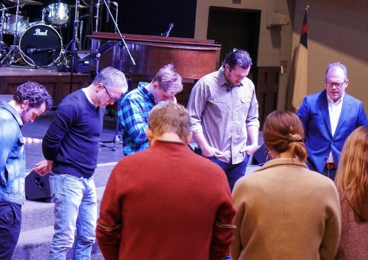 a group bowing their head in prayer